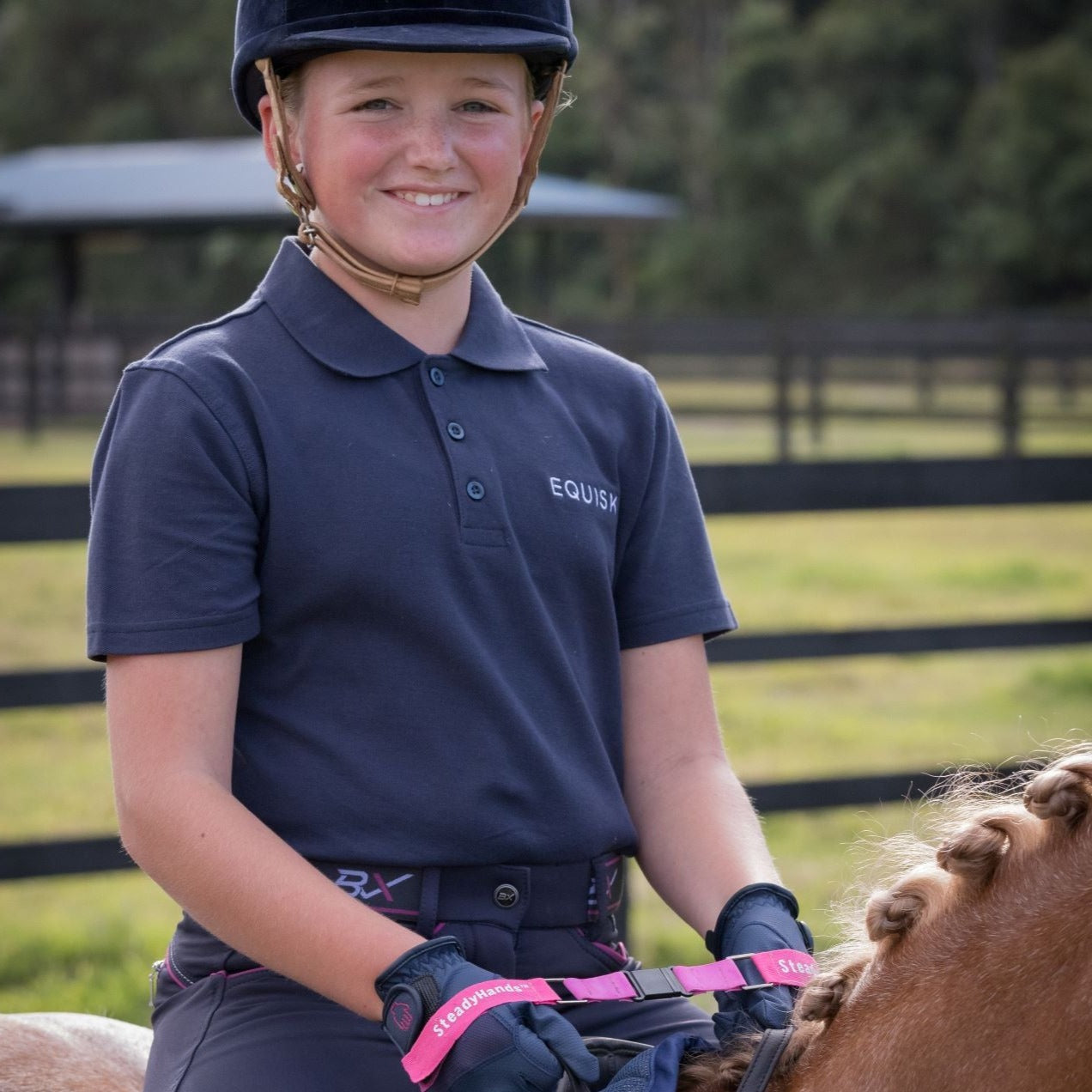 junior rider on chestnut show hunter pony smiling with steadyhands riding gloves