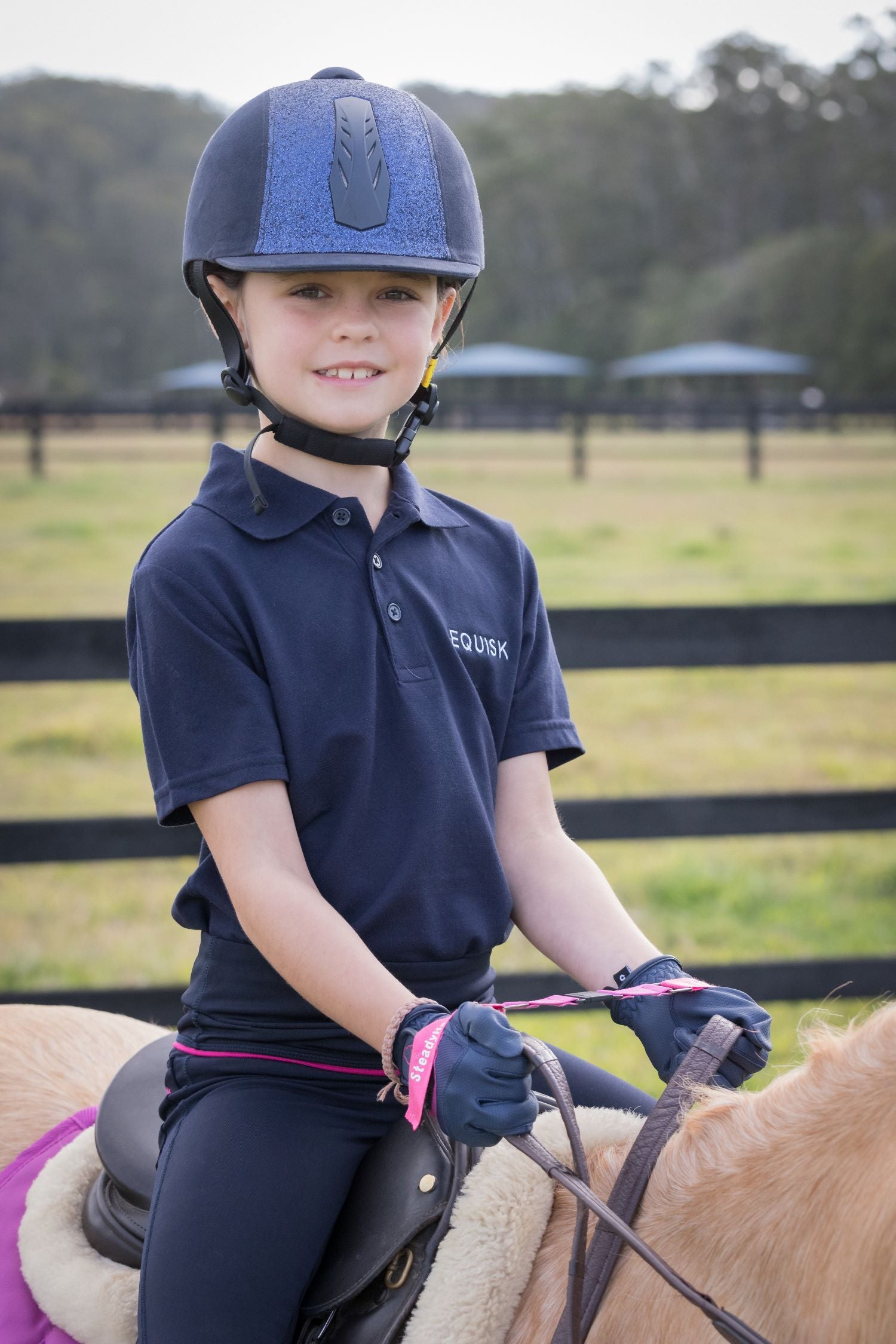 junior rider on palomino pony smiling with steadyhands riding gloves
