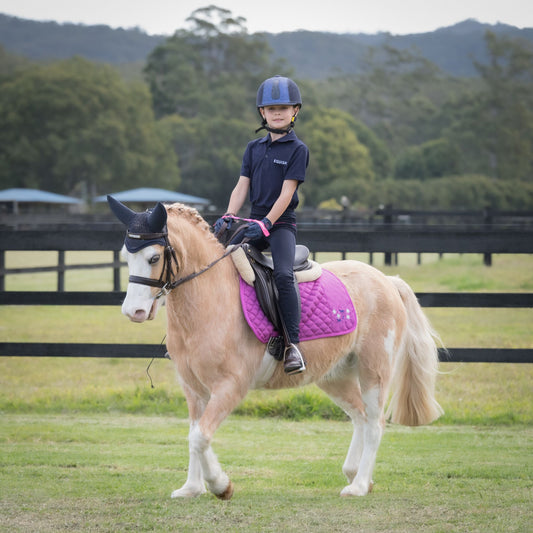 junior rider on palomino pony riding dressage and showing with steadyhands riding gloves